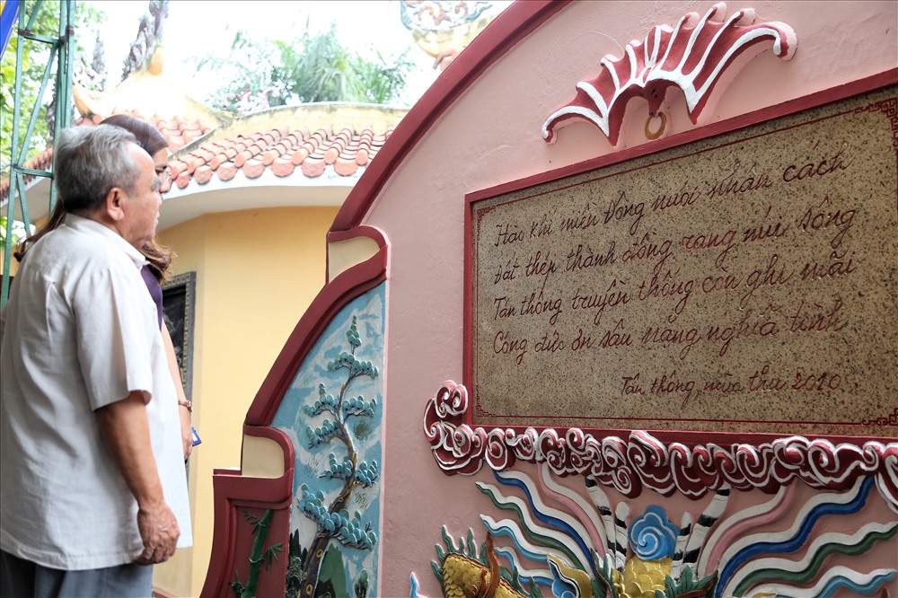 Ông Hưng trước tấm bia ghi lại bút tích của nguyên Thủ tướng Phan Văn Khải trong đình Tân Thông. Ảnh: Trường Sơn
