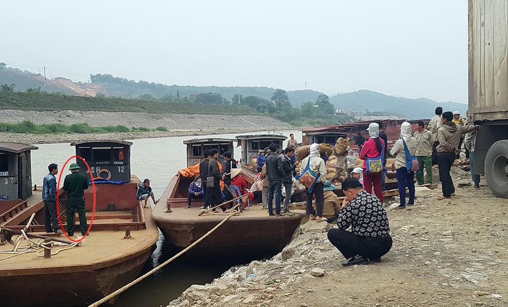 Mội người đàn ông trong tranh phục bộ đội biên phòng (khoanh đỏ) có mặt theo dõi toàn bộ quá trình xuất - nhập hàng hóa.