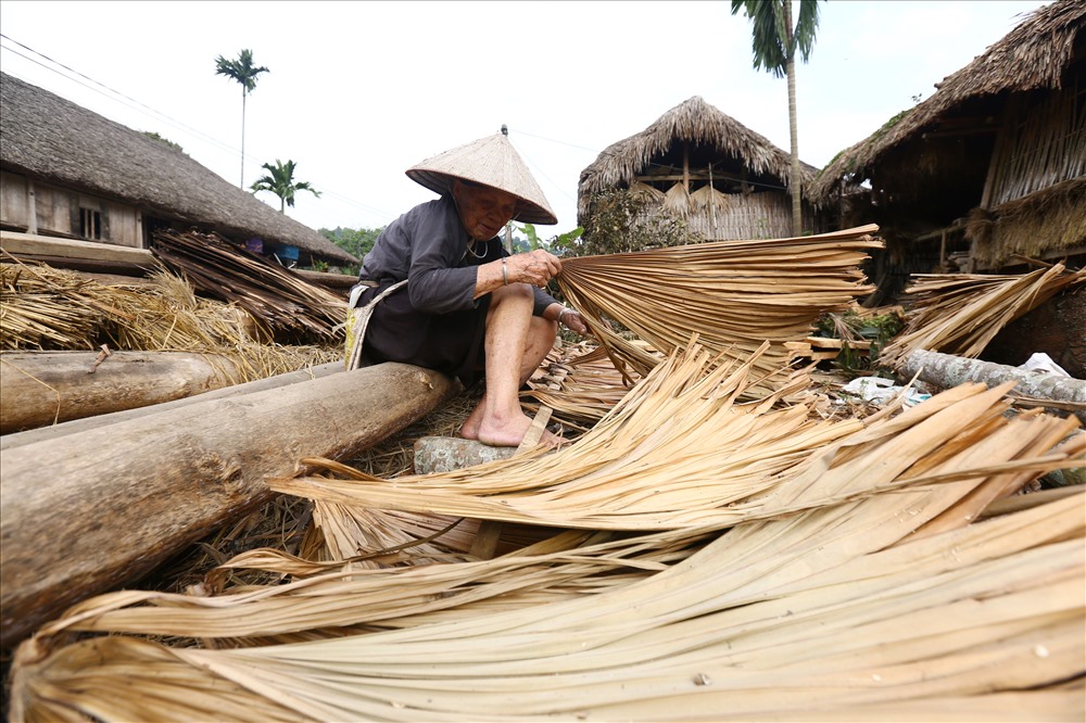 Bà Nguyễn Thị Minh (89 tuổi) ở bản Tha chuẩn bị lá để dựng một ngôi nhà sàn mới cho cậu con trai út ra ở riêng.