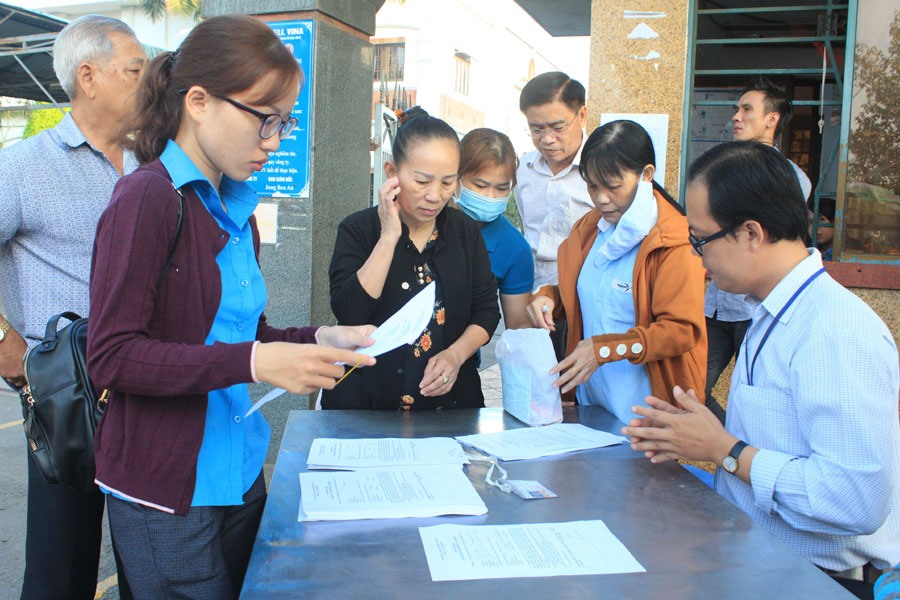 Cán bộ công đoàn giúp người lao động hoàn thành các thủ tục.