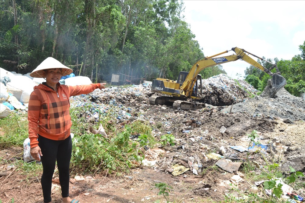 Thậm chí hộ dân gần đó phải thuê cơ giới đến đào hố để lấp bớt rác để giảm mùi hôi/ (Ảnh: Thanh Mai)