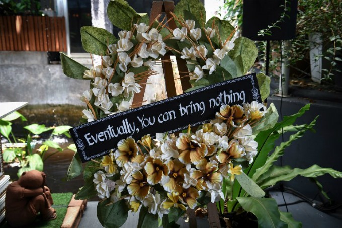 Một vòng hoa tang lễ với câu khẩu hiệu “Cuối cùng bạn cũng không mang theo được cái gì cả”, nhắc nhở con người giảm bớt lòng tham và sự tức giận khi còn sống. (Ảnh: AFP)