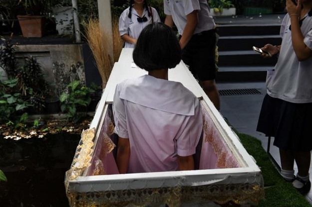 Theo Veeranut Rojanaprapa – một giáo sư và cũng là một nhà nghiên cứu xã hội học, khi những vị khách trẻ nằm trong quan tài, khi nắp quan tài đóng lại, bóng tối và không gian nhỏ hẹp trong đó sẽ khiến họ ý thức về chính bản thân họ,… Họ sẽ nhớ lại những điều mà họ vẫn chưa thực hiện được. Bởi “khi người ta nhận thức được cái chết của chính họ, họ sẽ làm việc tốt. Đó là những gì Đức Phật dạy chúng ta.” – ông Veeranut giải thích. (Ảnh: AFP)