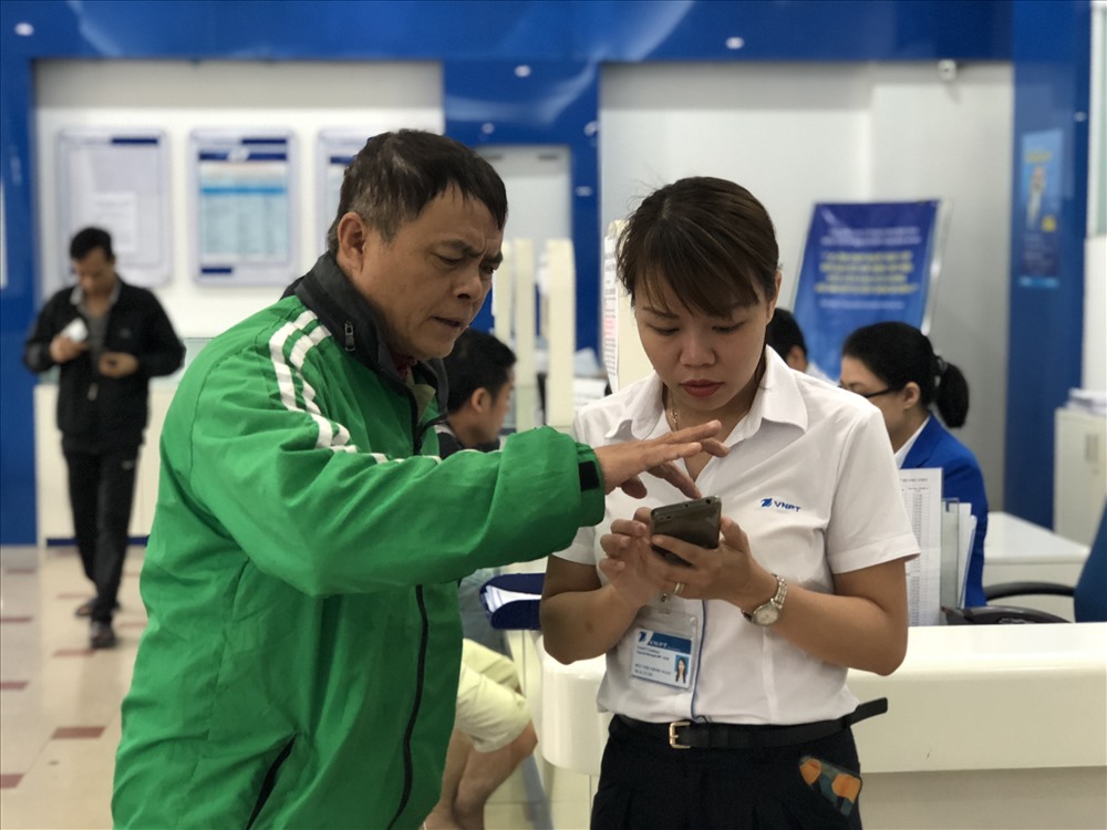 Chú tài xế Grab nhân lúc vắng khách cũng tranh thủ đến bổ sung thông tin vì lo lắng bị khóa sim