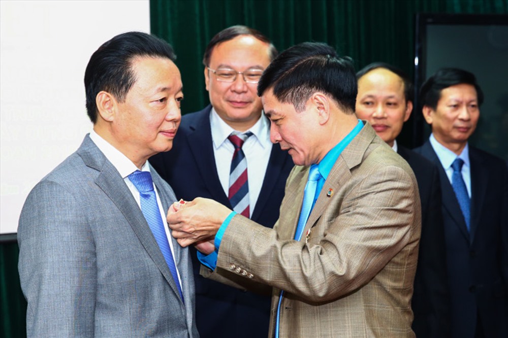 Chủ tịch Tổng LĐLĐVN Bùi Văn Cường trao Kỷ niệm chương “Vì sự nghiệp tổ chức công đoàn” cho Bộ trưởng Bộ Tài nguyên và Môi trường Trần Hồng Hà. Ảnh: SƠN TÙNG