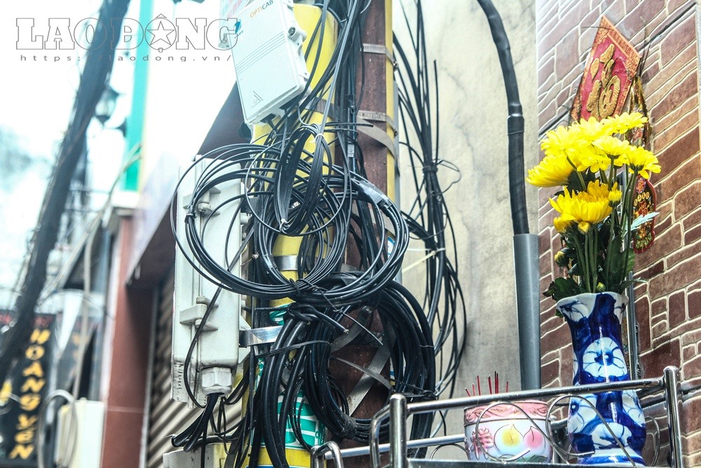 Lối vào khu chợ này chằng chịt dây điện, bên cạnh đó, nhiều tiểu thương còn lập bàn thờ ngay bên cạnh.
