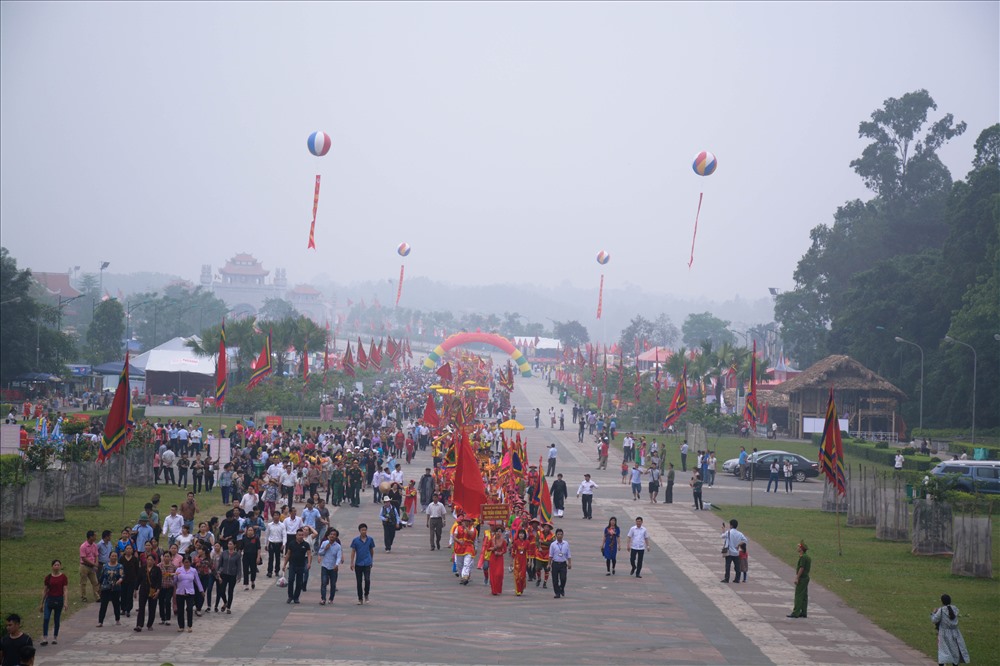 Đúng 7 giờ, đám rước với mầu sắc sặc sỡ, lộng lẫy bạt ngàn cờ, hoa, lọng, kiệu… và trang phục truyền thống được xếp thành hàng dài, xuất phát từ dưới chân núi về sân Trung tâm lễ hội, lên cổng Đền Hùng.