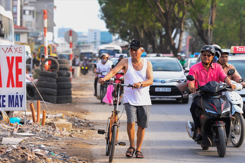 Đường Phạm Văn Đồng đang trong quá trình thi công nên người đi bộ phải đi xuống lòng đường. Ảnh: ST