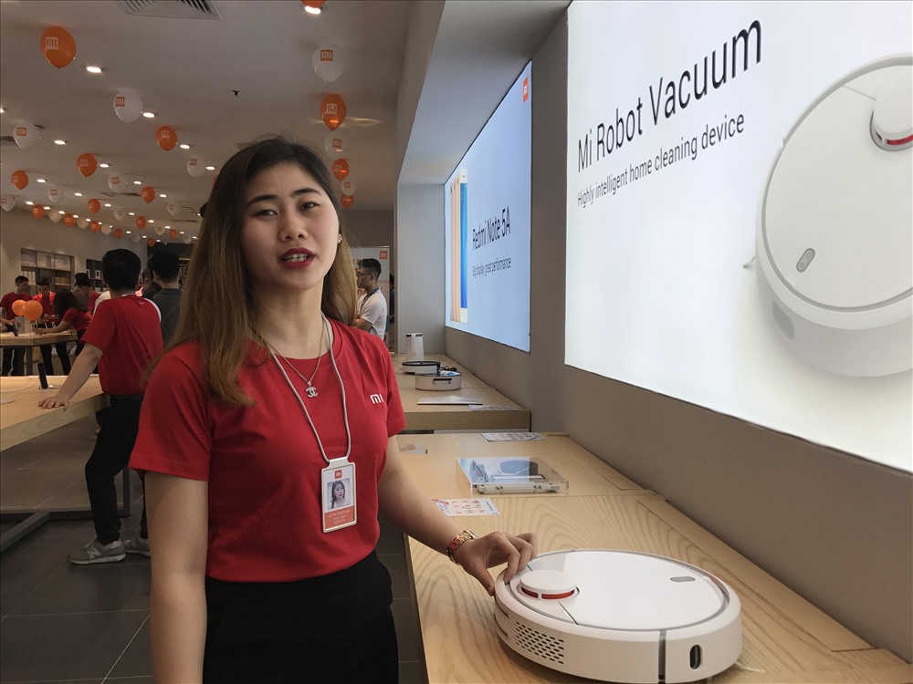 Nhân viên Xiaomi giới thiệu robot hút bụi tự nhận diện đường đi lối lại trong nhà.