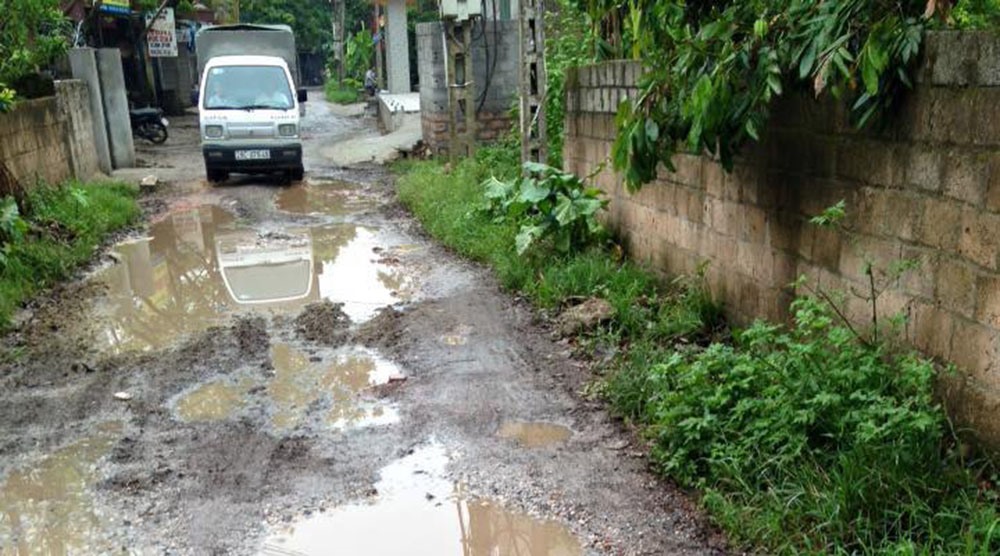 Vào trời mưa, việc di chuyển của người dân càng khó khăn hơn vì những hố nước. Ảnh: HN.