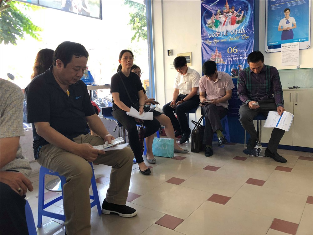 Trong lúc chờ đợi đến lượt, nhiều người tranh thủ lướt mạng.