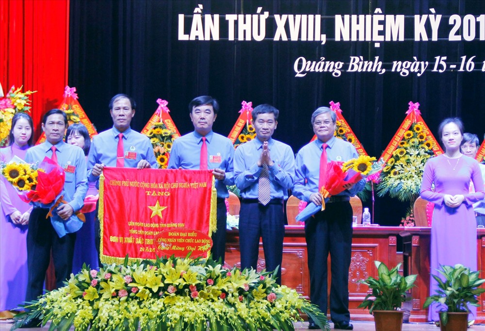 Phó chủ tịch Tổng LĐLĐ Việt Nam Trần Văn Thuật trao Cờ thi đua xuất sắc dẫn đầu cụm khối cho Công đoàn tỉnh Quảng Bình. Ảnh: Lê Phi Long
