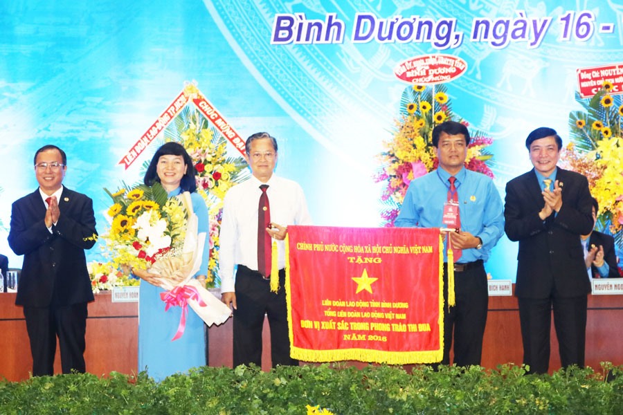Chủ tịch Tổng LĐLĐVN Bùi Văn Cường (ngoài cùng bên phải) trao cờ thi đua xuất sắc của Thủ tướng Chính phủ cho LĐLĐ tỉnh Bình Dương. Ảnh: PV