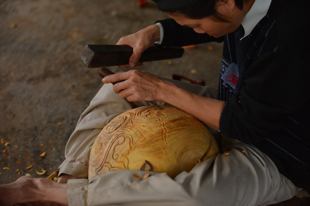 Ngồi khoanh chân ôm tròn lấy thân mõ là tư thế thường thấy của cánh thợ chạm.
