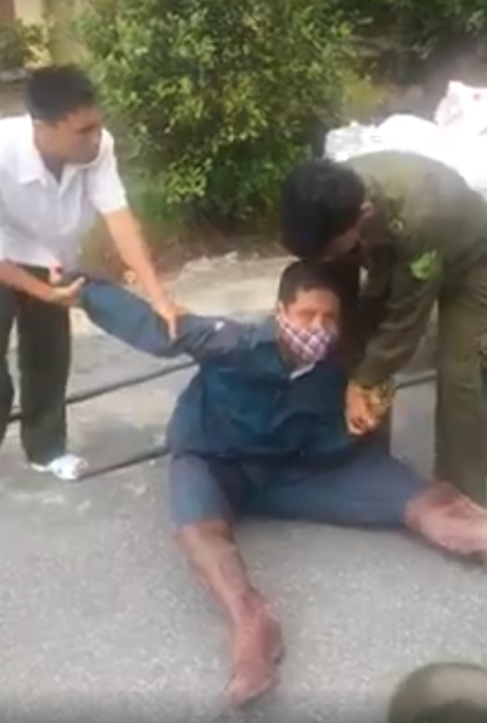 Lực lượng Công an xã khống chế người đổ rác trước cổng Ủy ban và đưa vào trụ sở làm việc.