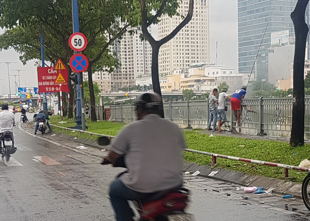 Cách hiện trường thiếu niên sẩy chân rơi xuống kênh chưng 1km, nhiều thanh thiếu niên vẫn đang vô tư giăng câu, bất chấp nguy hiểm. Ảnh: T.S