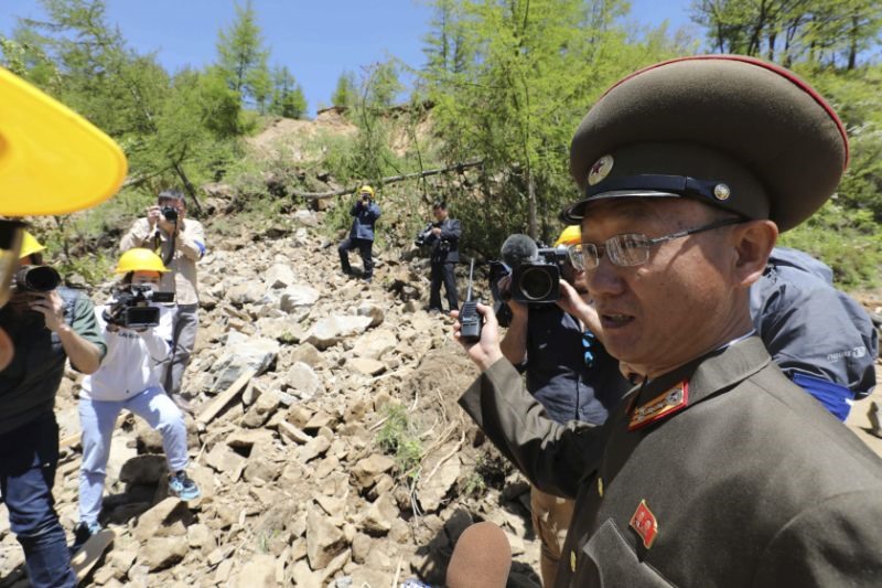 Một quan chức Triều Tiên chỉ cho phóng viên nước ngoài về đống đổ nát tại bãi thử hạt nhân sau khi hoàn tất việc phá hủy. Ảnh: AP. 
