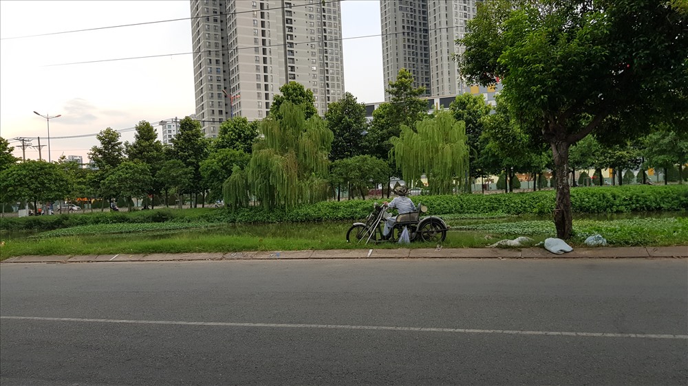 Thậm chí, một người khuyết tật vẫn liều lĩnh cho xe lăn lên lề đường chưa đầy 1m để ngồi câu cá. Ảnh: Trường Sơn