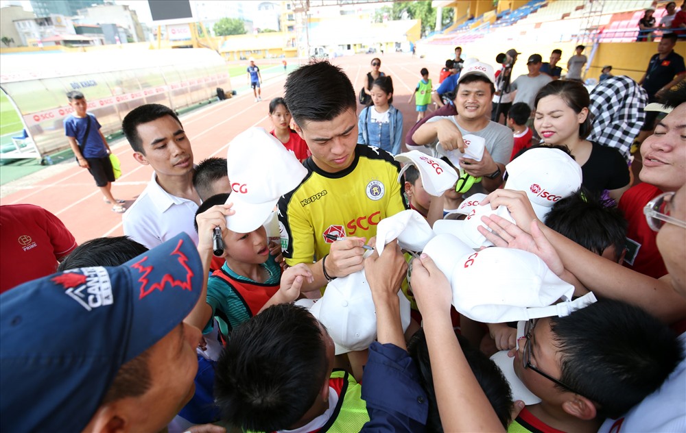 Duy Mạnh ký tặng mũ cho các em. Ảnh: H.A