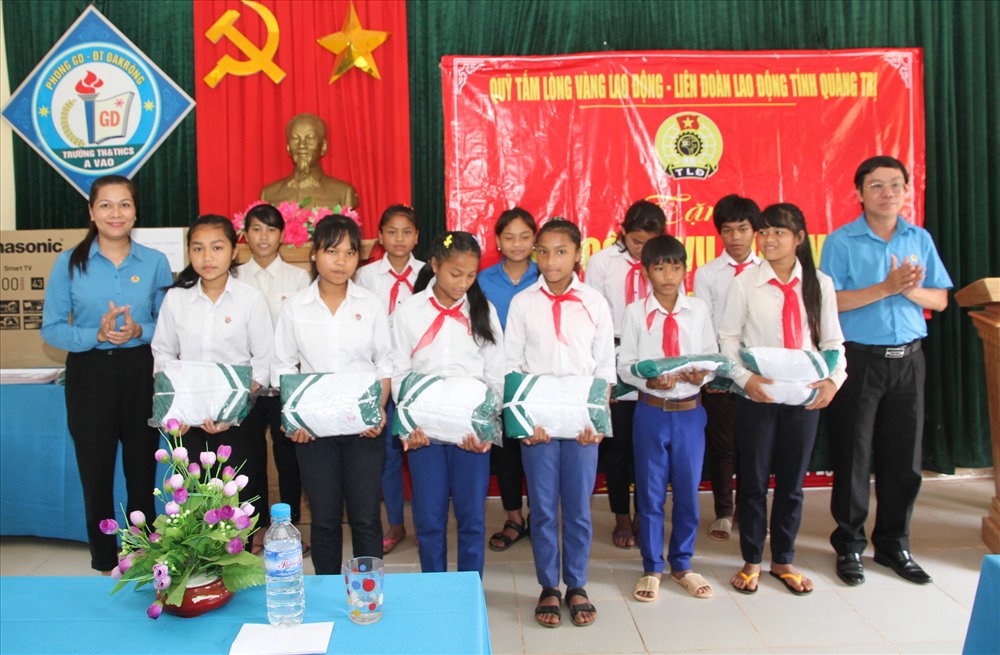 Lãnh đạo LĐLĐ tỉnh Quảng Trị trao quà cho học sinh Trường TH&THCS A Vao. Ảnh: Hưng Thơ.