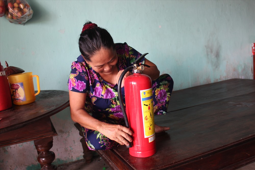 Bà Lượng chủ nhà tập sử dụng bình chữa cháy.
