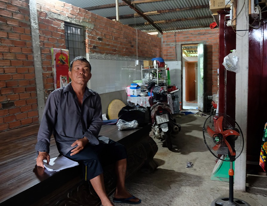 Ông Đặng Văn Minh thẫn thờ trong căn nhà tạm bợ trên chính mảnh đất của mình. Ảnh: PV