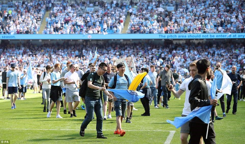 CĐV Man City tràn xuống sân ăn mừng sau tiếng còi mãn cuộc trận đấu. Ảnh: PA.