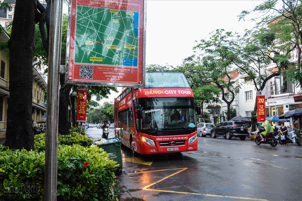 Hình ảnh những chiếc bus mui trần vẫn miệt mài đón trả khách ở các điểm đợi mặc kệ trời mưa.