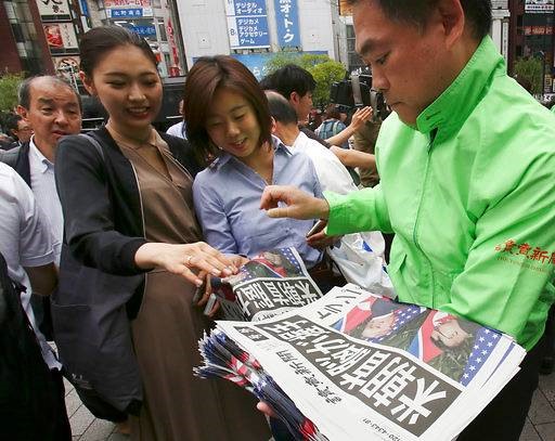Một nhân viên tờ Yomiuri, Nhật Bản phát ấn bản thêm của tờ báo về hội nghị thượng đỉnh Mỹ - Triều tại ga Shimbashi ở Tokyo. Ảnh: AP. 
