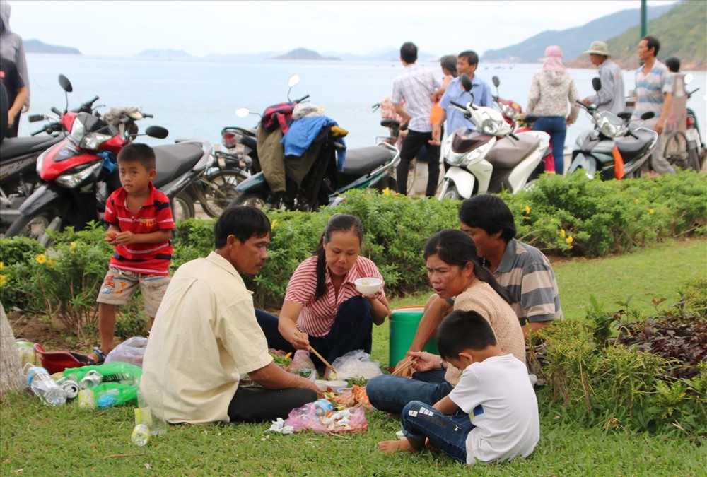 Những gia đình ở xa, họ tổ chức ăn uống, vui chơi dưới những tán cây ven biển nơi đây. Ảnh. Đ.Phùng