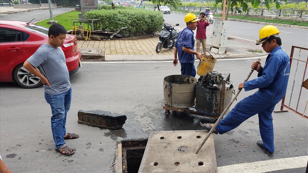 Tại miệng cống nằm trên đường quẹo từ Nguyễn hữu Cảnh ra thắng máy bơm, các công nhân đưa lên một tảng xà bần lớn. Ảnh: Trường Sơn