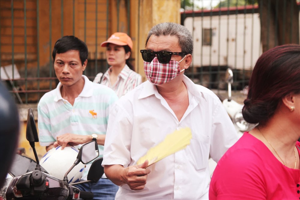 Nhiều người “hành trang” cho mình kính râm, quạt tay, nước lọc... đợi con hoàn thành bài thi. Ảnh: Anh Phú