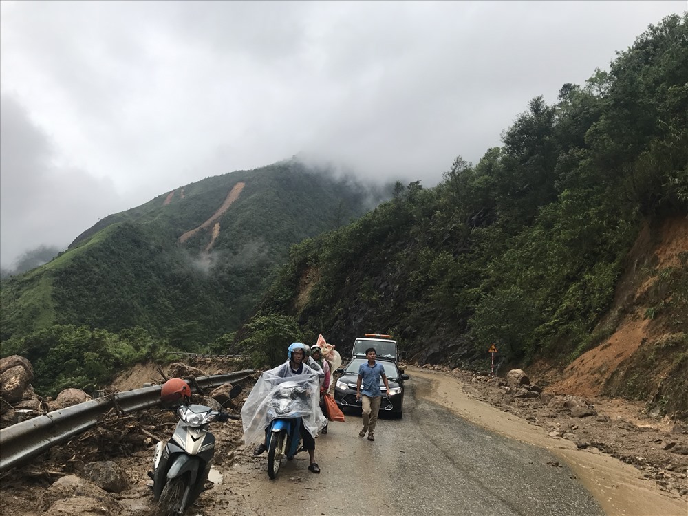 Các xe dừng đỗ tạm thời chờ đến lượt đi qua nơi sạt lở. Trong khi trời vẫn tiếp tục mưa.