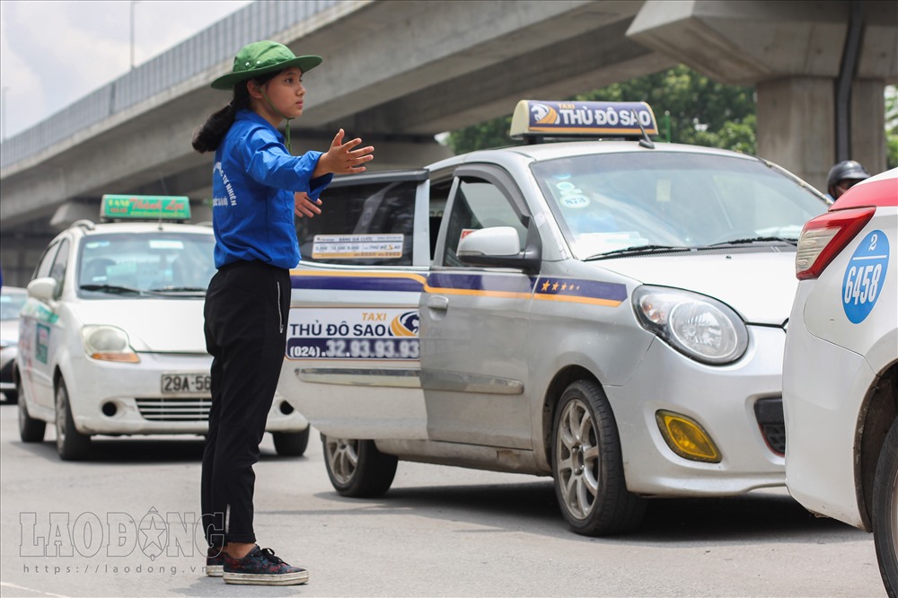 Các tình nguyện viên vất vả trong việc nhắc nhở các phương tiện không được dừng đỗ trước cổng trường.