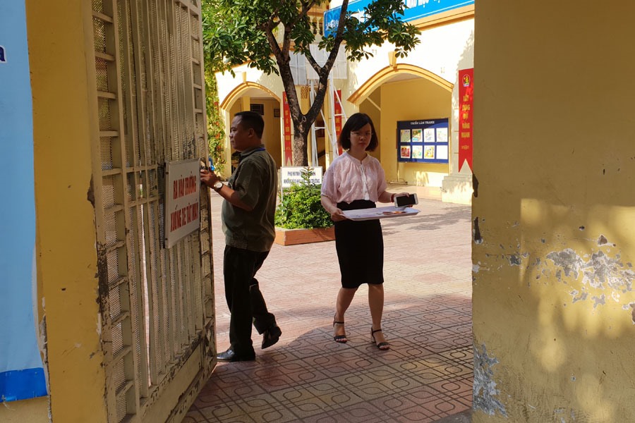 Người phụ nữ “lạ” không đeo thẻ nhưng liên tục đi lại trong thời gian thi tại điểm thi THCS Phan Đình Giót. Ảnh: HN