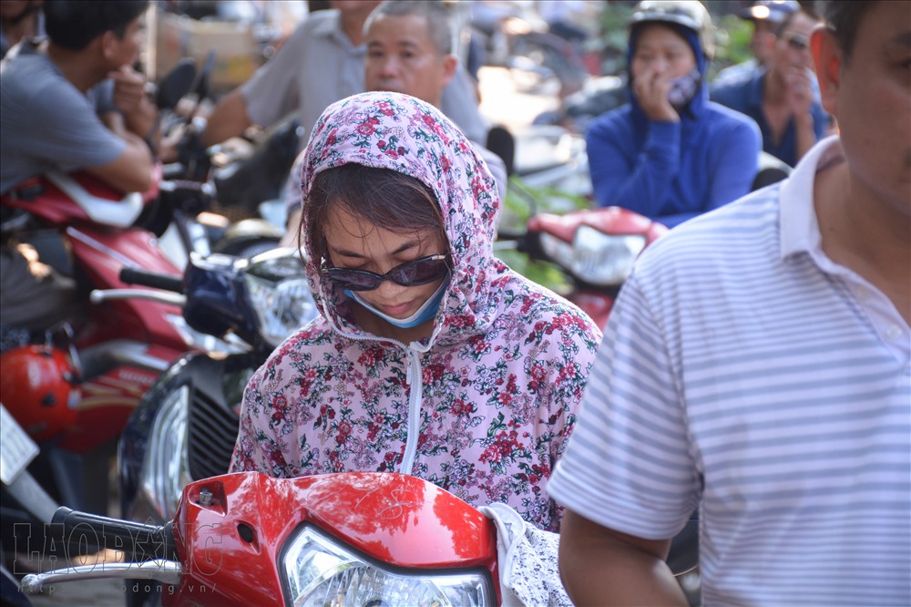 Chờ con quá lâu, một người phụ nữ ngủ gật khi vẫn khoác trên người chiếc áo chống nắng.