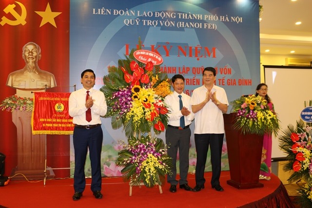 Các ông Nguyễn Tiến Dĩnh - nguyên Thứ trưởng Bộ Nội vụ, nguyên Chủ tịch LĐLĐ TP. Hà Nội; Lê Đình Hùng - Phó Chủ tịch LĐLĐ TP. Hà Nội tặng lẵng hoa chúc mừng 10 năm thành lập Quỹ Trợ vốn Hanoi FEI. Ảnh: Quỹ Trợ vốn Hanoi FEI