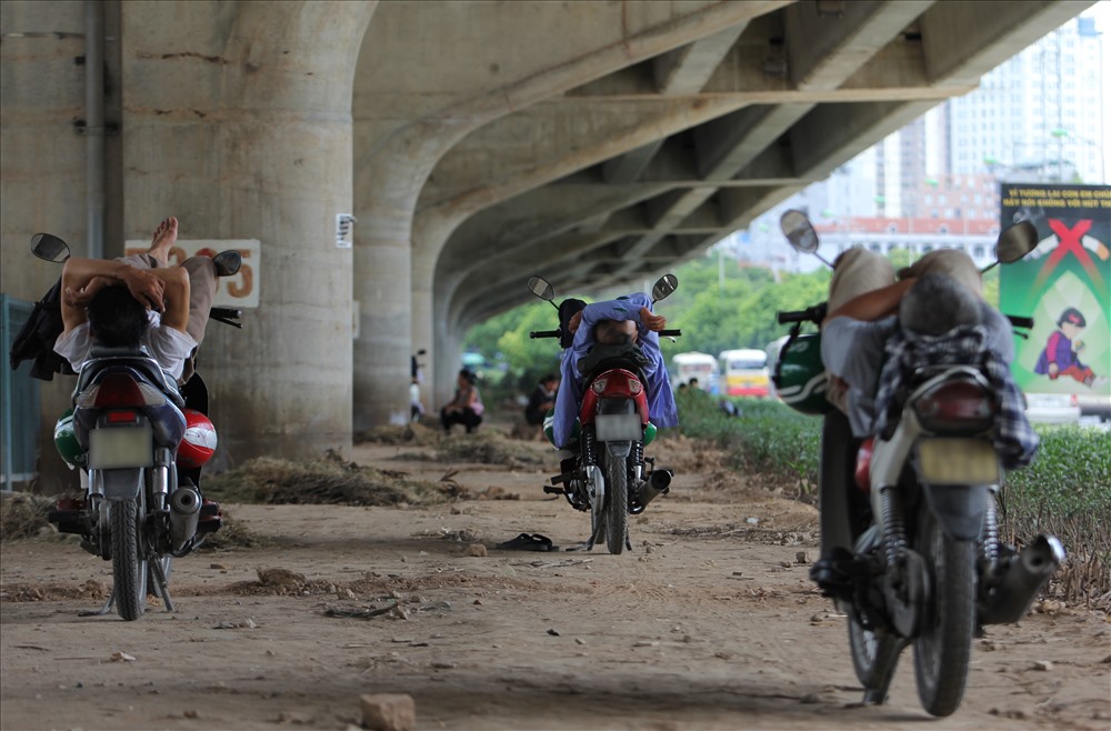 “Trưa nắng nóng thế này cũng ít khách nên tranh thủ chợp mắt một lúc. Trời này mà chạy xe ngoài đường cũng rất nguy hiểm, bởi rất dễ bị say nắng” Một người chạy xe ôm tại bến xe Mỹ Đình chia sẻ.