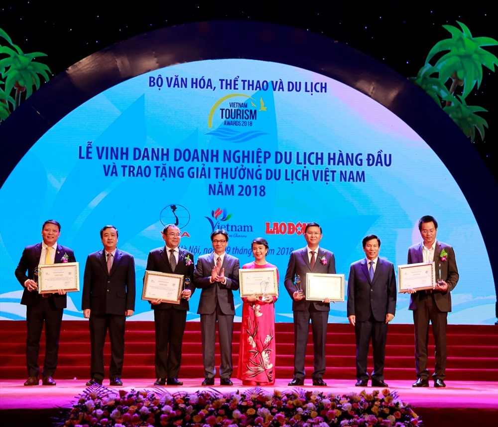Bà Hoàng Thị Mỹ Hạnh – Phó Tổng Giám đốc Công ty Cổ phần Vinpearl (áo dài đỏ) nhận giải Doanh nghiệp đầu tư và kinh doanh du lịch hàng đầu Việt Nam.