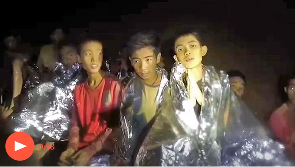 Những cậu bé còn mắc kẹt trong hang được lực lượng cứu hộ vỗ về, an ủi. Ảnh: Guardian.