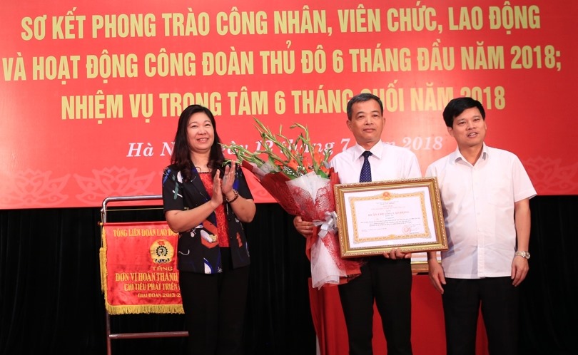 Ông Ngô Văn Quý - Phó Chủ tịch UBND TP. Hà Nội (bên phải) và bà Nguyễn Lan Hương - Ủy viên Ban Thường vụ, Trưởng ban Dân vận Thành ủy Hà Nội trao Huân chương Lao động hạng Ba của Chủ tịch Nước tặng thưởng và hoa chúc mừng cho ông Vũ Kim Sơn - nguyên Phó Chủ tịch LĐLĐ TP. hà nội. Ảnh: Hải Nguyễn