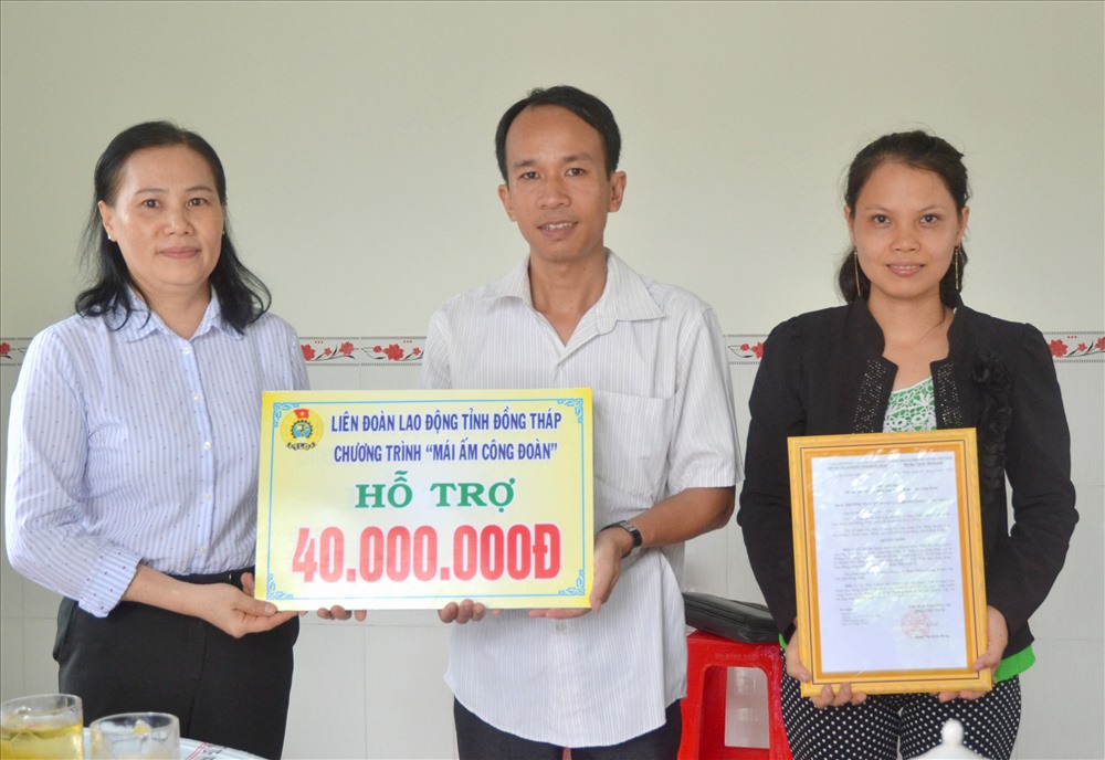 Phó Chủ tịch LĐLĐ Đồng Tháp Đặng Thị Kim Đang trao quyết định và bảng tượng trưng mức hỗ trợ MÂCĐ cho gia đình anh Trần Hoàng Anh. (Ảnh: Lục Tùng)
