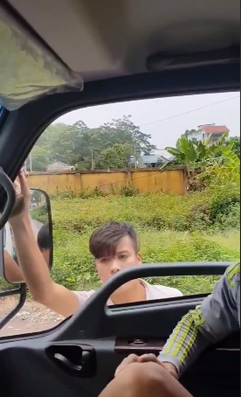 Nam thanh niên này liên tục dùng tay đập vào cửa xe nhưng trong xe không ai mở cửa. Ảnh cắt từ clip