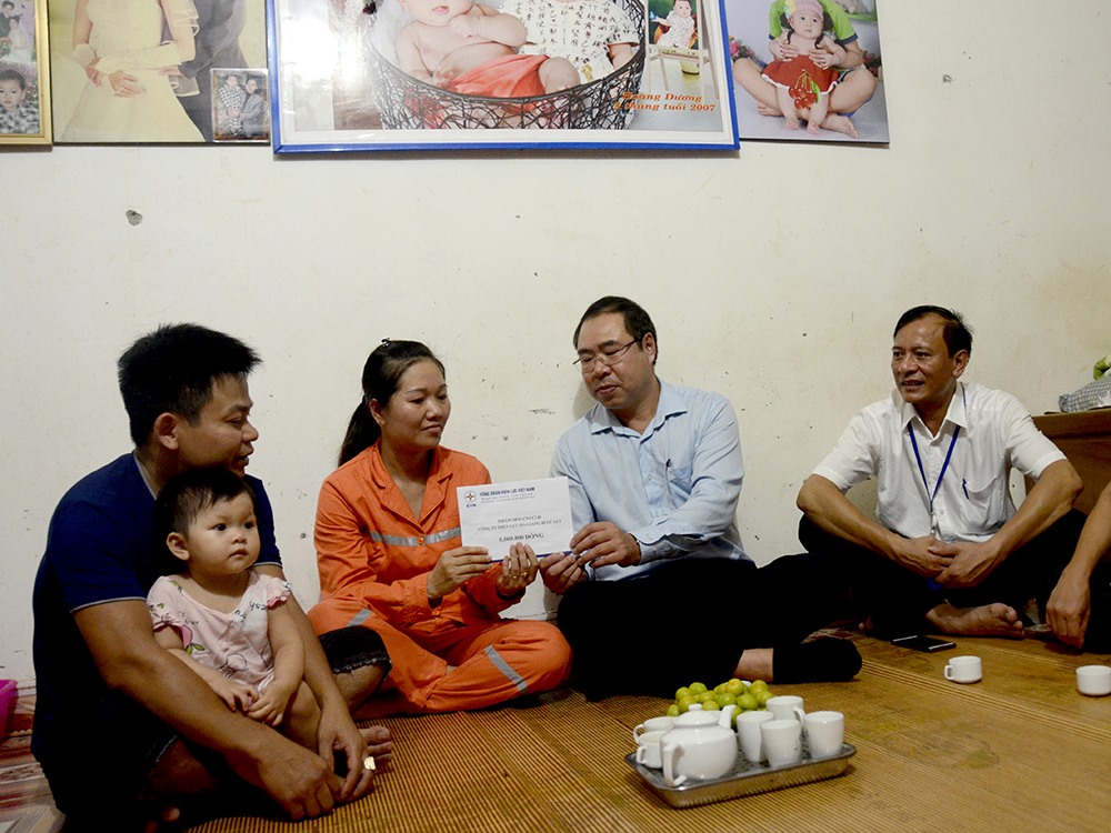 Ông Đỗ Đức Hùng, Phó Chủ tịch Công đoàn Điện lực Việt Nam (thứ hai bên phải sang) sẻ chia, động viên gia đình chị Hoàng Phương Mẫn, công nhân Điện lực TP Hà Giang thuộc Công ty Điện lực Hà Giang bị thiệt hại nặng nề sau đợt mưa lũ vừa qua. Ảnh: Đ.L