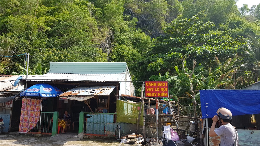 Dòng chữ cảnh báo khu vực nguy hiểm do sạc lở núi ngay trước lối vào khu dân cư dưới chân núi Ba Hòn. Ảnh: T.S