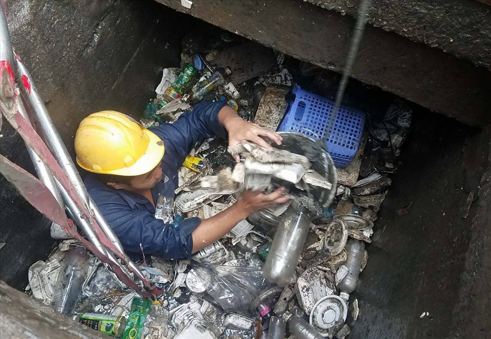 Rác ngập cống khiến công nhân thoát nước rất vất vả vớt rác.