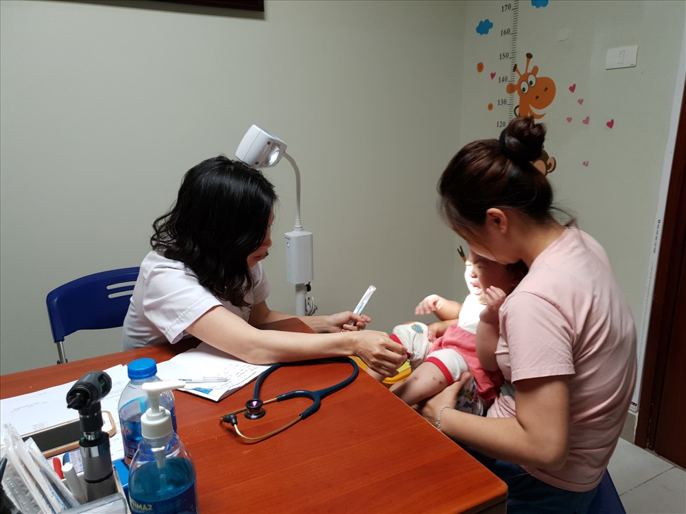 BS Út khám cho một bệnh nhi bị đau bụng. Ảnh: T.Linh