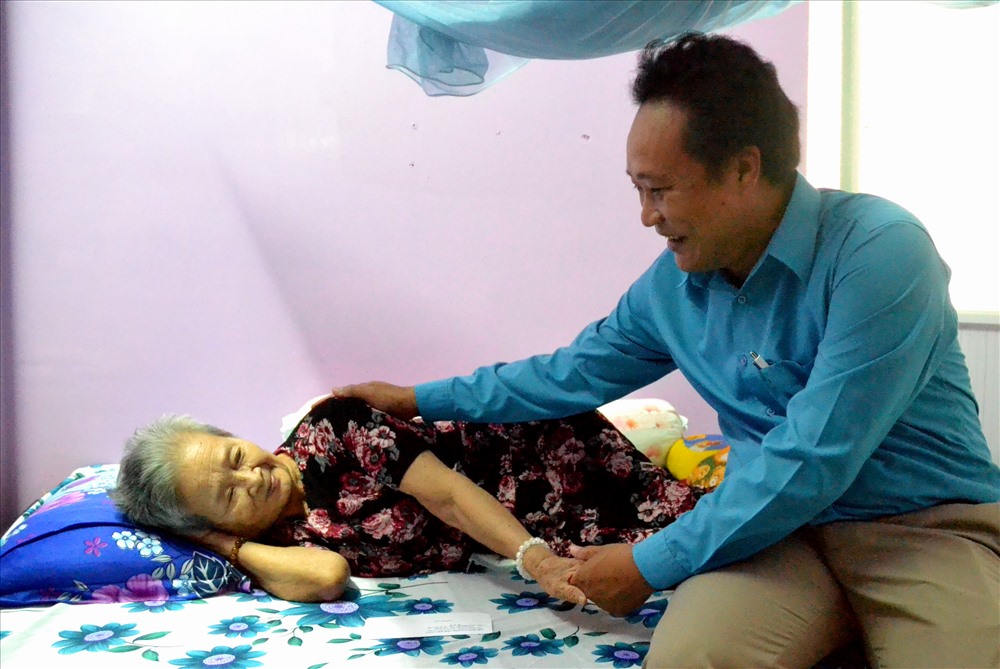 Ông Đằng vào tận giường thăm hỏi, chúc sức khỏe cô Võ Thị Liễu. Ảnh: Lục Tùng.
