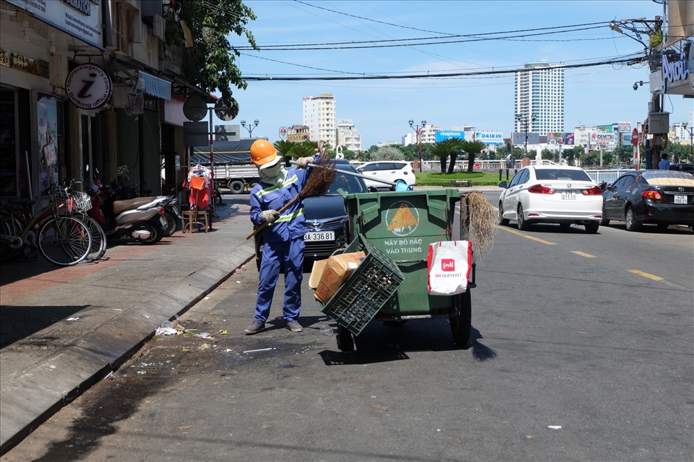 Nhân viên vệ sinh đang dọn rác vào buổi trưa