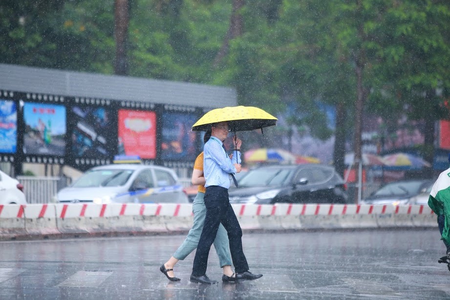 Trận mưa chỉ đủ làm ướt đường nhưng cũng khiến người đi đường cảm thấy thoải mái, nhẹ nhõm hơn. Ảnh: Trần Thường